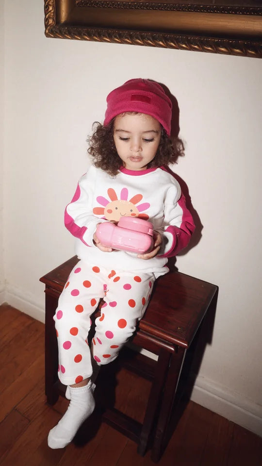 toddler in a polka dot set on a wooden stool