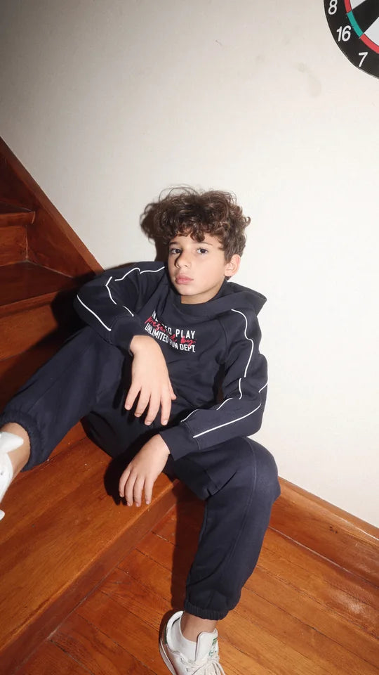 boy in a navy tracksuit on the stairs