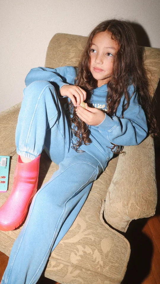 girl in a denim blue tracksuit and pink boots
